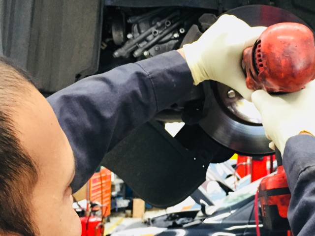 Kia auto repair mechanic servicing the brakes