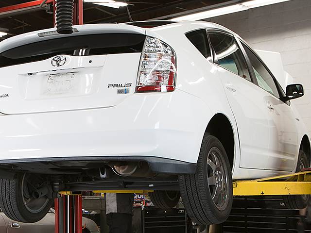 White Toyota Prius being repaired on a rack at A+ Japanese Auto Repair in San Carlos